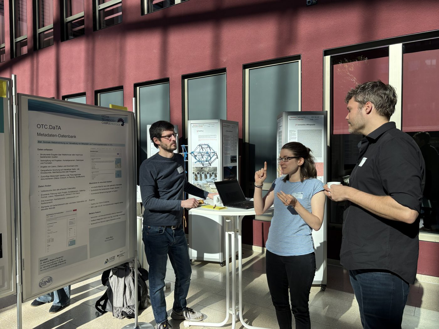 Colleagues in conversation at a poster at the Ocean Technology Campus cluster meeting