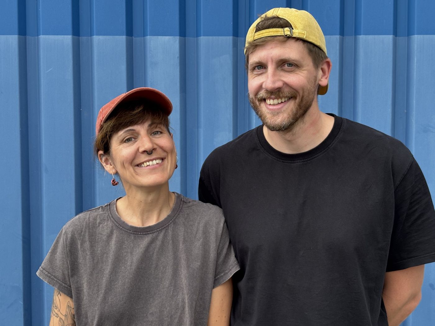 Stoffel and Claudia Korb smiling in front of a blue wall